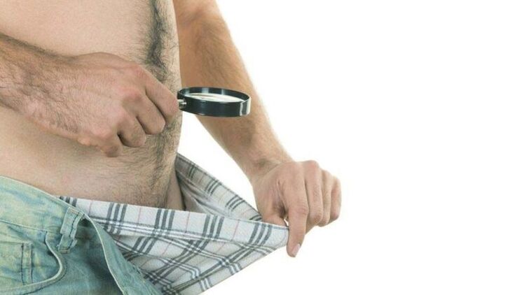 A man looks into his underpants and thinks about penis enlargement with lemonade